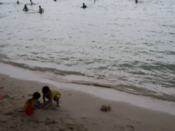 Immagini sfocate di bambini che giocano in spiaggia . — Foto Stock