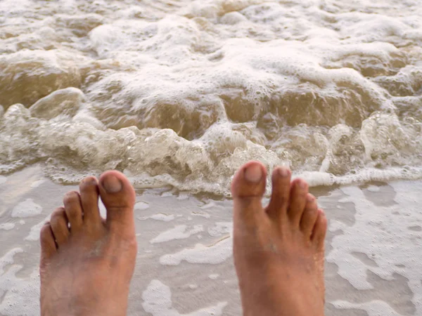 Men's Foot  on the white sand near the sea. — Stock Photo, Image