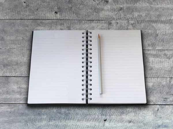 Notebook e lápis sobre fundo de madeira. — Fotografia de Stock