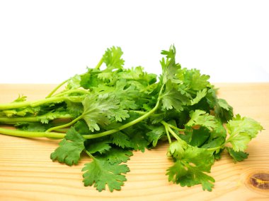 Taze kişniş yaprakları ahşap zemine konur..