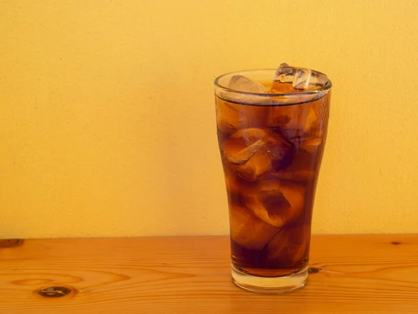 Vidro de cola com cubos de gelo na mesa . — Fotografia de Stock