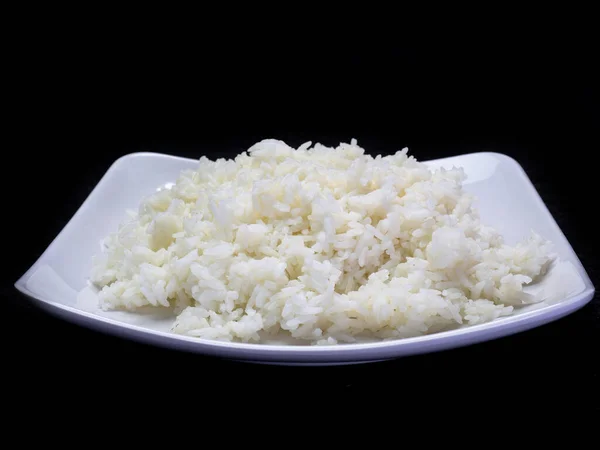 Bowl full of rice on a black background. — Stock Photo, Image