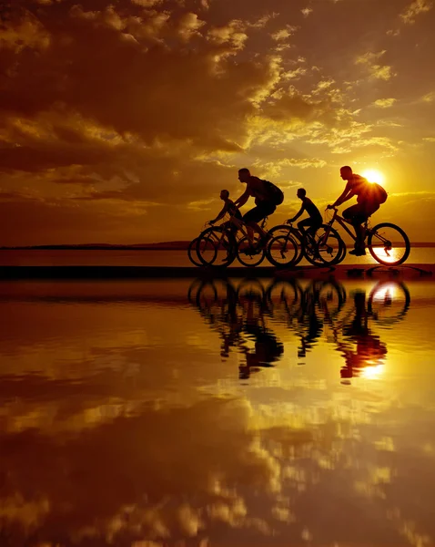 Freunde auf Fahrrädern bei Sonnenuntergang — Stockfoto