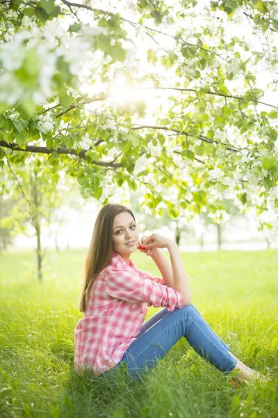 girl sitting under blomming tree