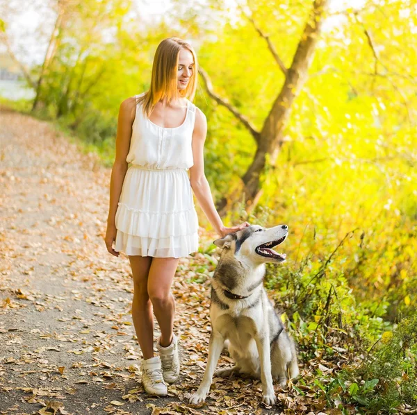 Žena se psem v podzimním parku. — Stock fotografie