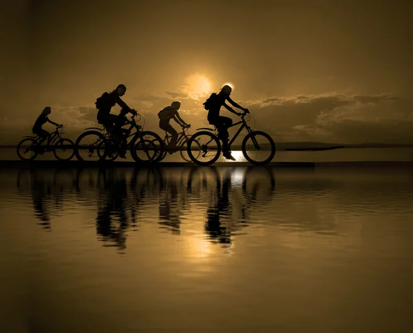 Freunde auf Fahrrädern bei Sonnenuntergang — Stockfoto