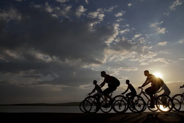 Friends on bicycles at sunset — Stock Photo, Image