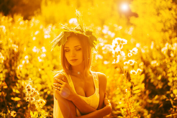 Blond Model Posing With Closed Eyes against sunset yellow light.