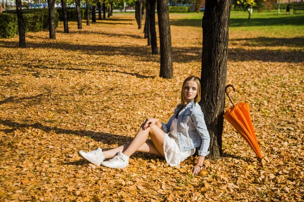 Frau sitzt neben Baum — Stockfoto