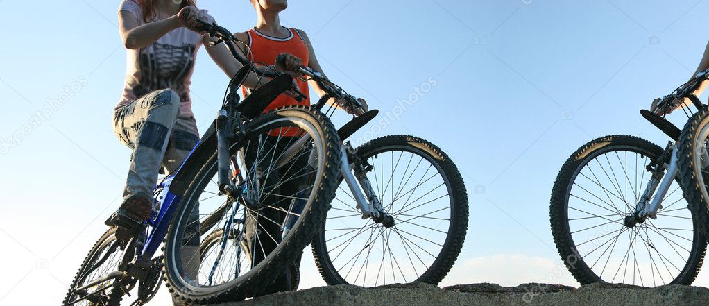 bicyclists standing on edge of rock