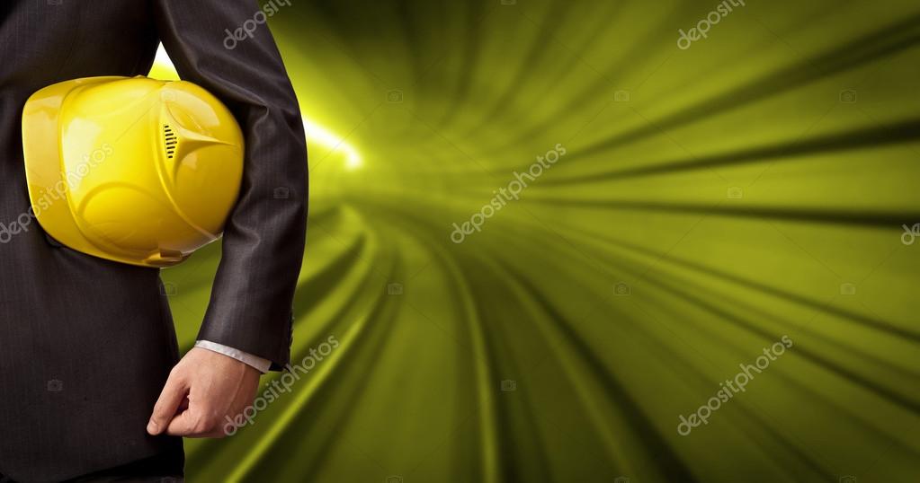 Engineer or worker  holding yellow helmet for workers security against the background of an underground mine