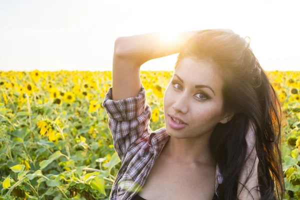 Junge Frau in Sonnenblumen — Stockfoto