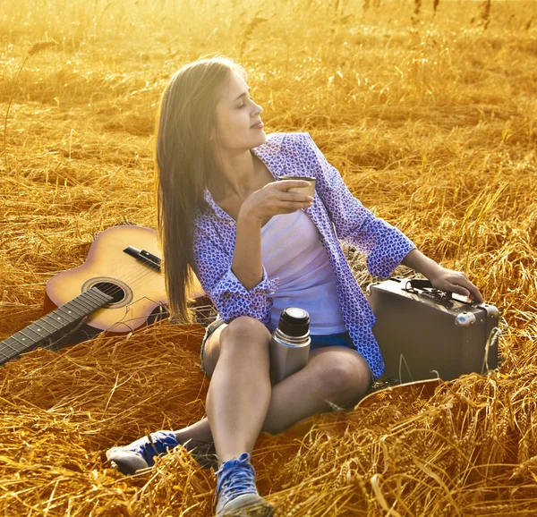 Κορίτσι με ρετρό βαλίτσα παίζει κιθάρα — Φωτογραφία Αρχείου