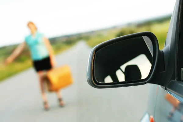 Meisje met een koffer op de weg. — Stockfoto