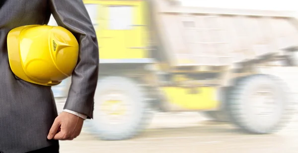 Trabalhador segura na mão capacete amarelo — Fotografia de Stock