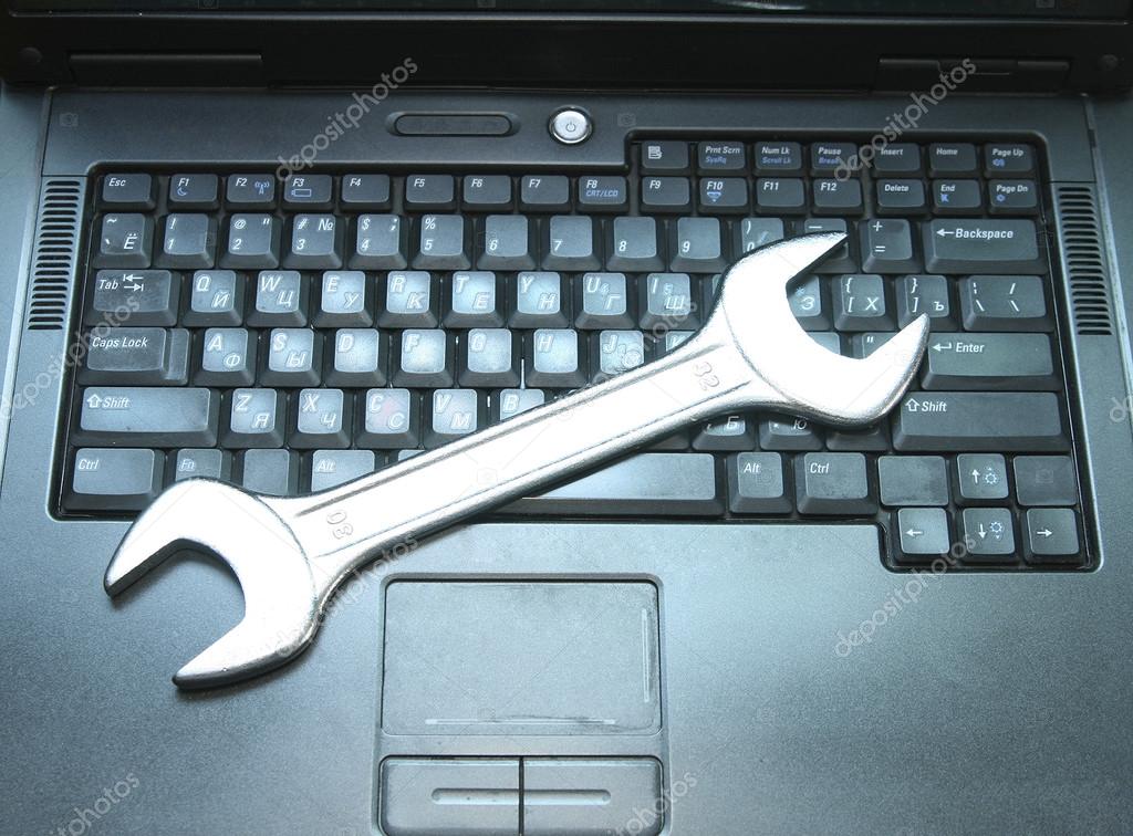 Background of wrench  on black laptop keyboard