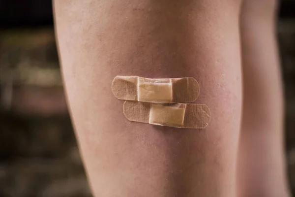 adhesive bandages on the leg