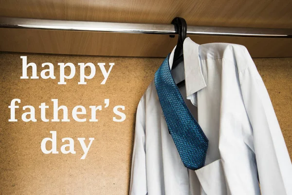 white shirt and blue tie hanging in wardrobe