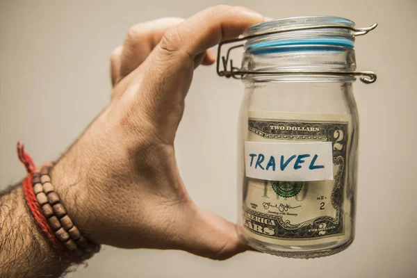 Man's hand holds jar with dollars — Stock Photo, Image