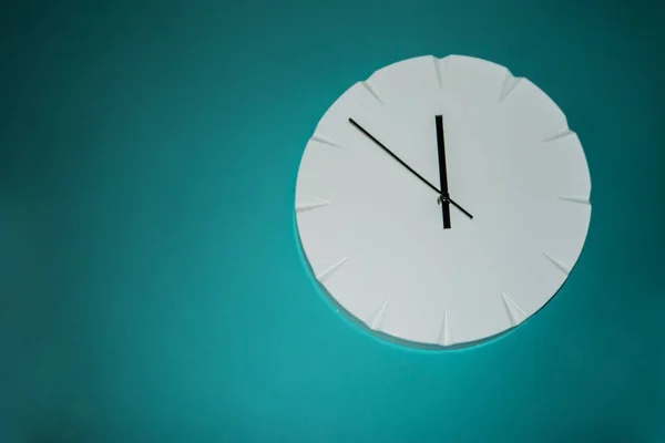 Weiße Uhr hängt an türkisfarbener Wand — Stockfoto