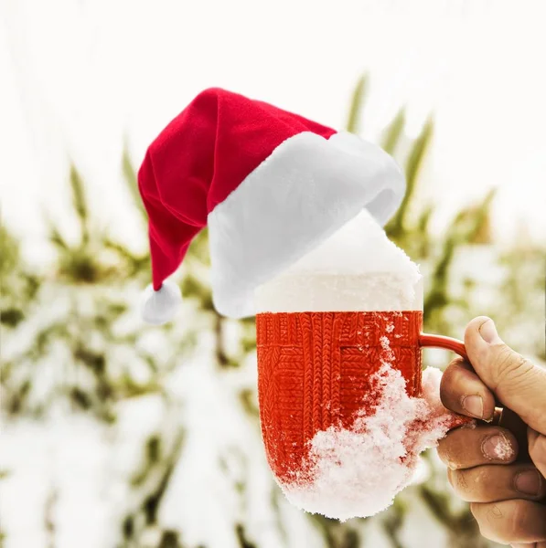 Männerhand mit Tasse und Weihnachtsmütze — Stockfoto