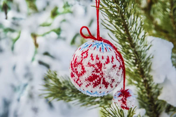 Gebreide Kerstbal op besneeuwde spar — Stockfoto