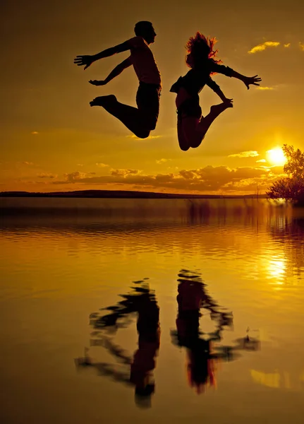 Silhouette Couple Man Woman Jumping Beach Sunset Cloudy Sky Orange — Stock Photo, Image