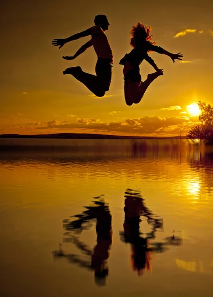 Silhueta Casal Homem Mulher Pulando Praia Pôr Sol Céu Nublado — Fotografia de Stock