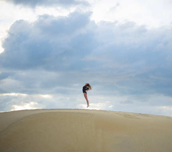woman jumping  up in desert. 