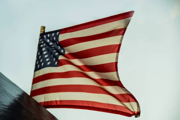 hanging USA flag over blue sky