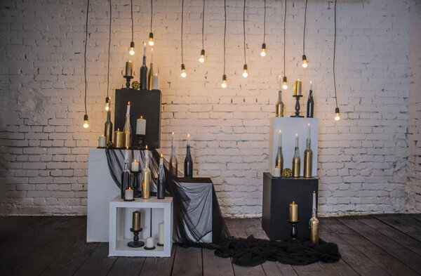 Candles in bottles on white and black cubes  