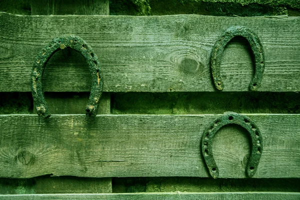 Parede com três ferraduras enferrujadas . — Fotografia de Stock