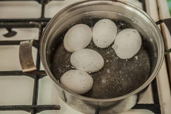 Ovos brancos em água fervente — Fotografia de Stock