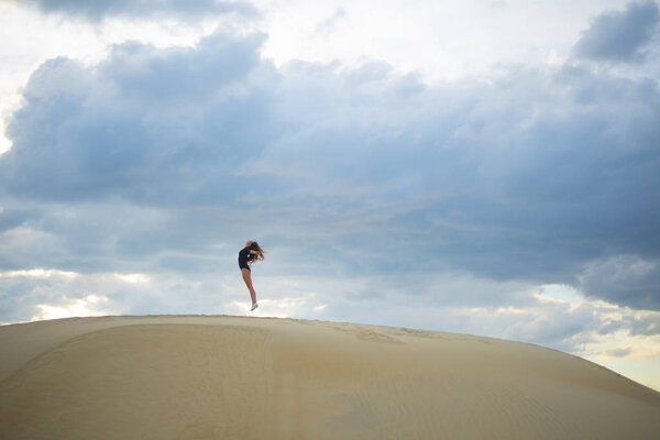 woman jumping  up in desert. 