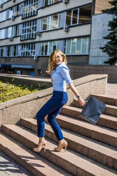 Young beautiful businesswoman walking  down the stairs with brief case
