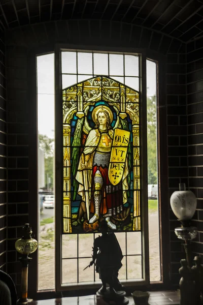 聖サムソン大聖堂のステンドグラスの窓からは大天使マイケルが描かれています 聖マイケルは剣と盾の足で悪魔を角で踏みつけ — ストック写真