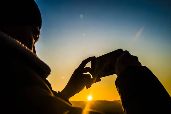 Silueta Las Manos Del Hombre Sosteniendo Teléfono Móvil Atardecer Sobre — Foto de Stock