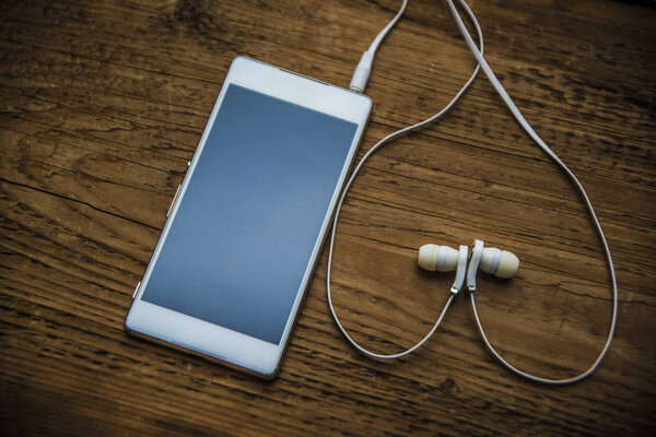 white Mobile phone and earbuds  