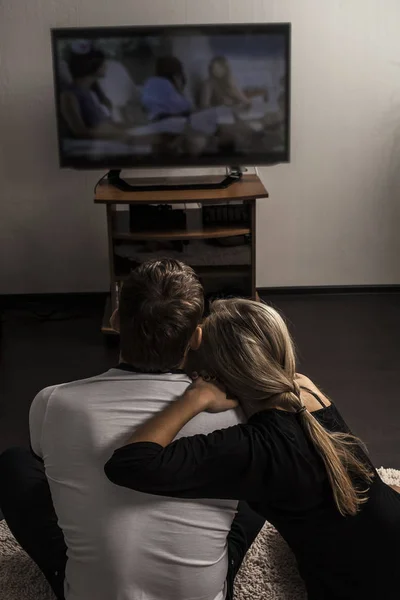 couple watching  tv set