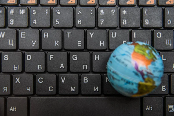 Globe on black laptop keyboard — Stock Photo, Image