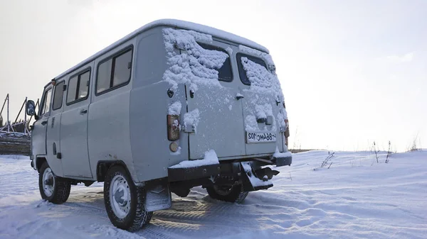 Auto op sneeuw coverd land. — Stockfoto