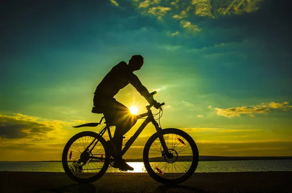 Pusta spacja. Sportowy człowiek na rowerze na zachodzie słońca. Sylwetka męski cy — Zdjęcie stockowe