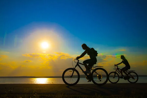 Σπορ Φίλους Στα Ποδήλατα Στο Ηλιοβασίλεμα Σιλουέτες Των Ποδηλατών Στην — Φωτογραφία Αρχείου