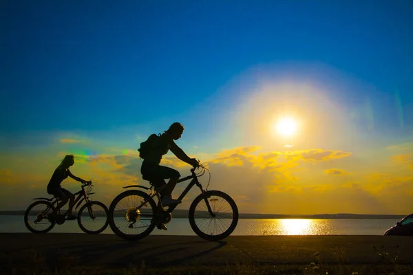 Empty Space. Sporty friends on bicycle on sunset. Silhouette cou — Stock Photo, Image