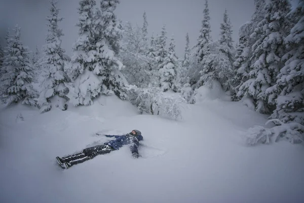 Jovem mulher deitada na neve — Fotografia de Stock