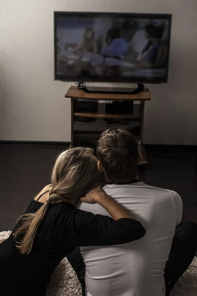couple watching  tv set