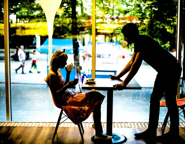 Kafe içinde flört eden çift. kadın içecek kahve ve siluet — Stok fotoğraf