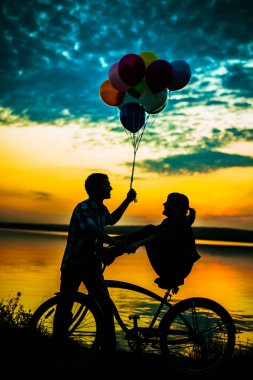 Romantik randevuda birbirine bakan iki kişinin siluetleri.