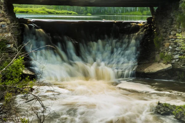 Wasserfall unter hölzerner Transportbrücke. — Stockfoto