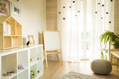 Taburesi ve resim masası olan anaokulu odası. Çocuk odası ve mobilya 